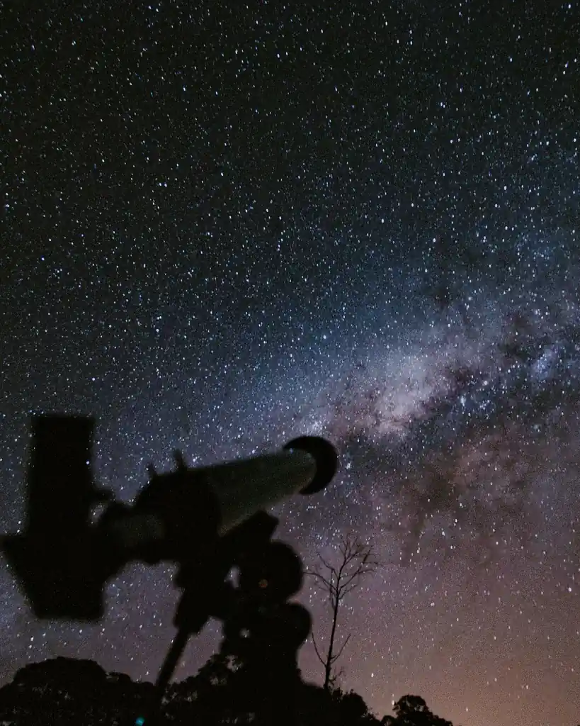 Telescope silhouette against the cosmos