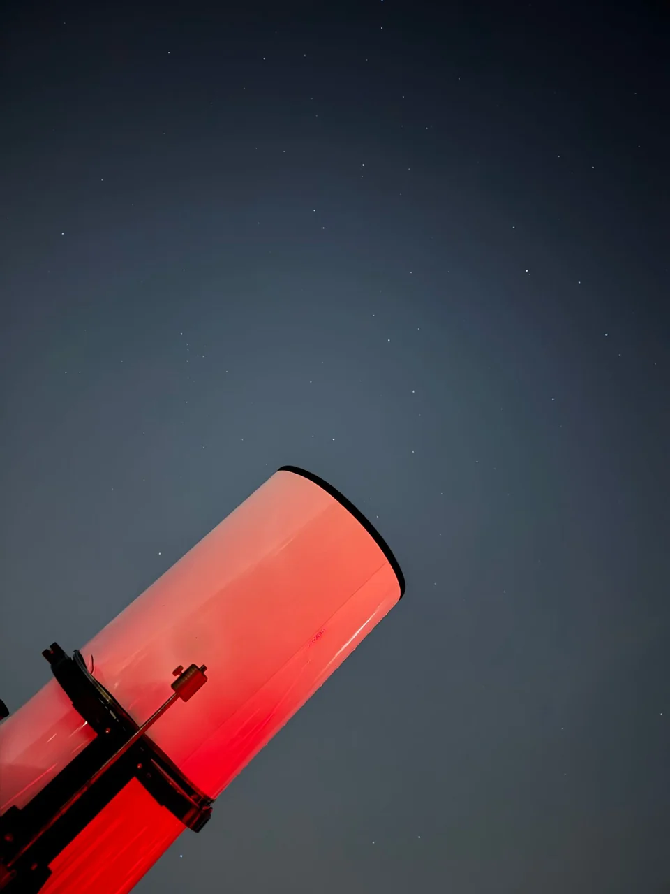 Professional telescope illuminated against a dark sky